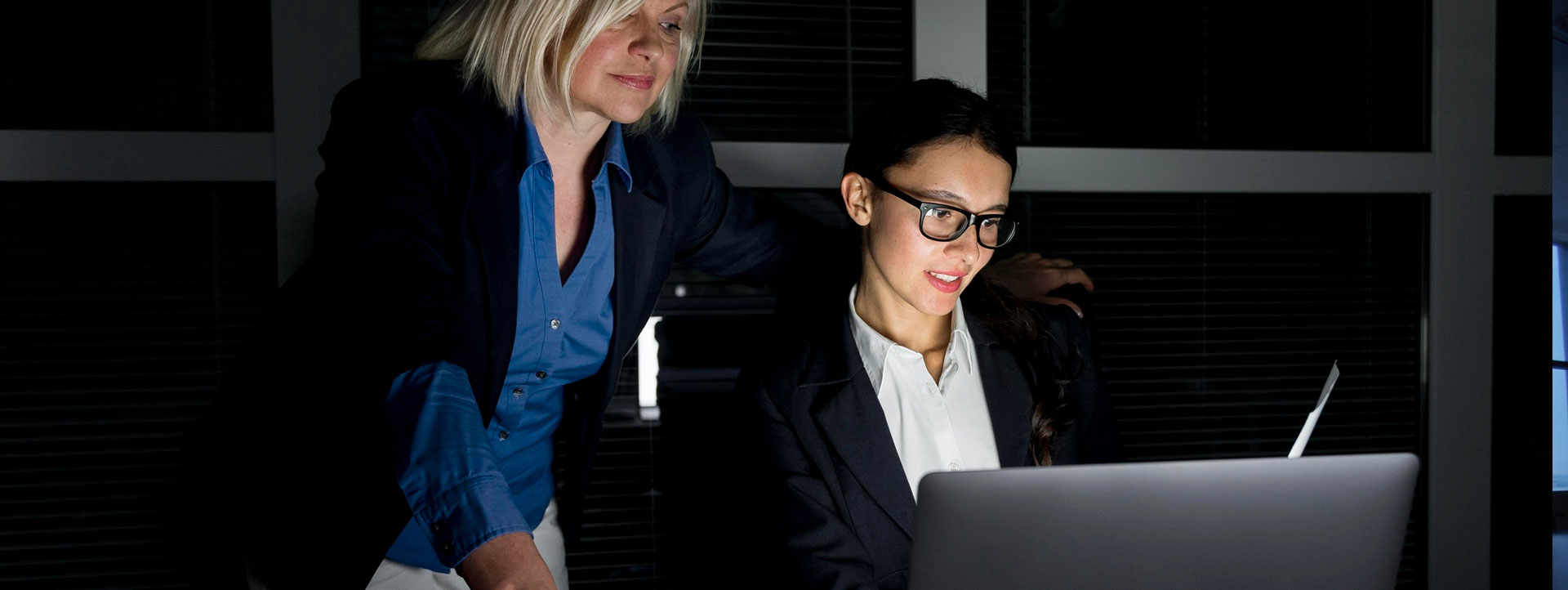 Two professionals collaborating on a laptop during the design process, representing a company that specializes in industries like healthcare and computer design.
