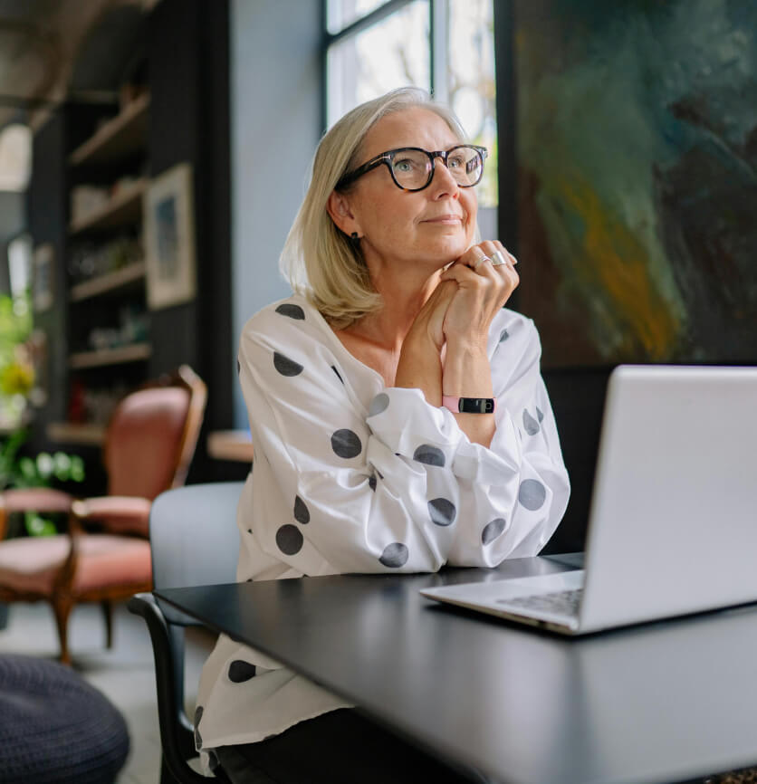 Professional woman working on a laptop, reflecting on digital agency growth, integrity, project management, and sustainable business solutions.