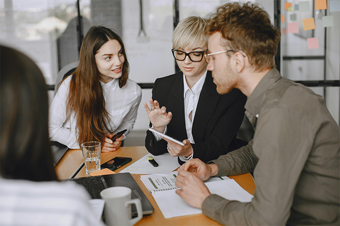 Team of professionals discussing business strategies in an office setting, representing a retail digital marketing company that provides strategic analysis, growth opportunities, 24/7 support, and results-oriented marketing solutions for businesses.