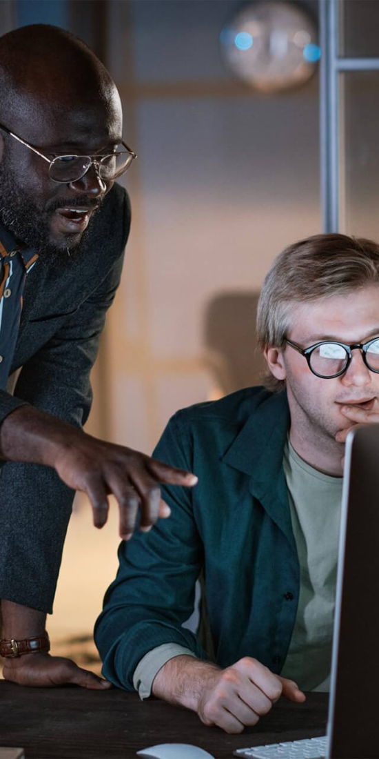 Two professionals reviewing data on a computer, reflecting investment policy decision-making and strategic financial planning in a focused workspace.