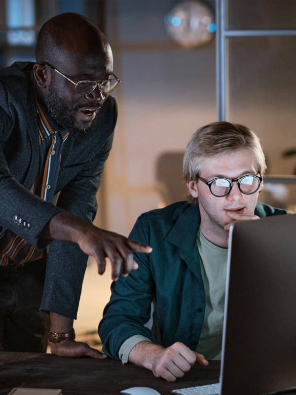 Two professionals reviewing data on a computer, reflecting investment policy decision-making and strategic financial planning in a focused workspace.