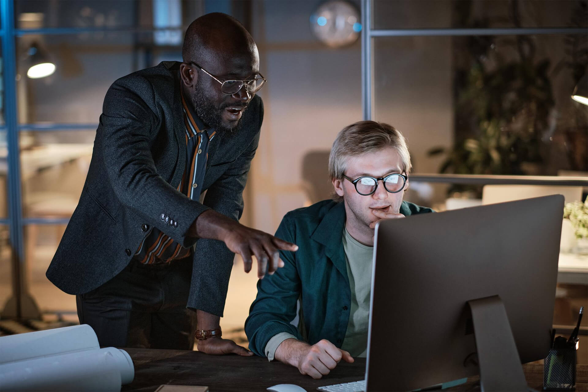Two professionals reviewing data on a computer, reflecting investment policy decision-making and strategic financial planning in a focused workspace.