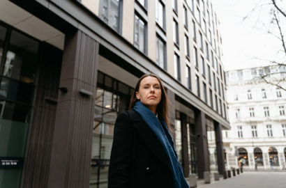 A confident professional standing outside a modern office building, symbolizing innovation and growth in E-Commerce and Market strategies.