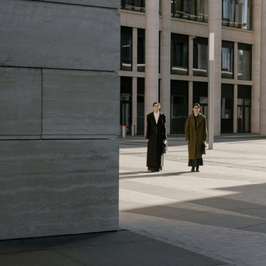 Two professionally dressed individuals walk together in a modern business district with tall office buildings, symbolizing collaboration and readiness to discuss new projects and opportunities.