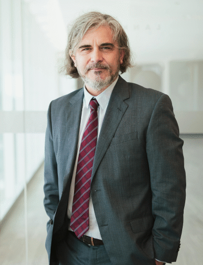 Confident businessman in a suit standing in a modern office, representing the experienced and professional UreSuccess team focused on driving business growth.