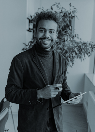 Smiling professional holding a digital tablet during a team meeting, representing unity and collaboration in a modern office—highlighting the confidence that comes with partnering with Stratify-Tax/VAT for accurate, real-time bookkeeping.
